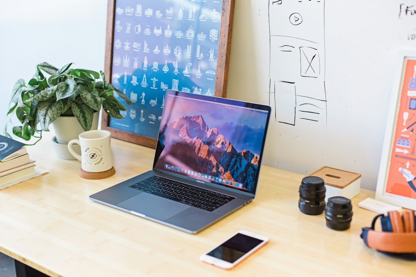 Laptop on a wooden desk with office supplies.