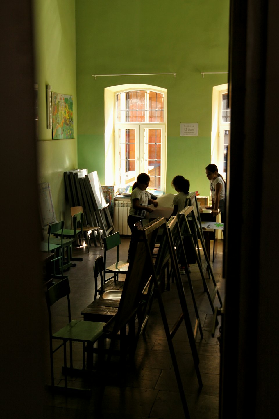 Three students prepare for an art class in a studio.